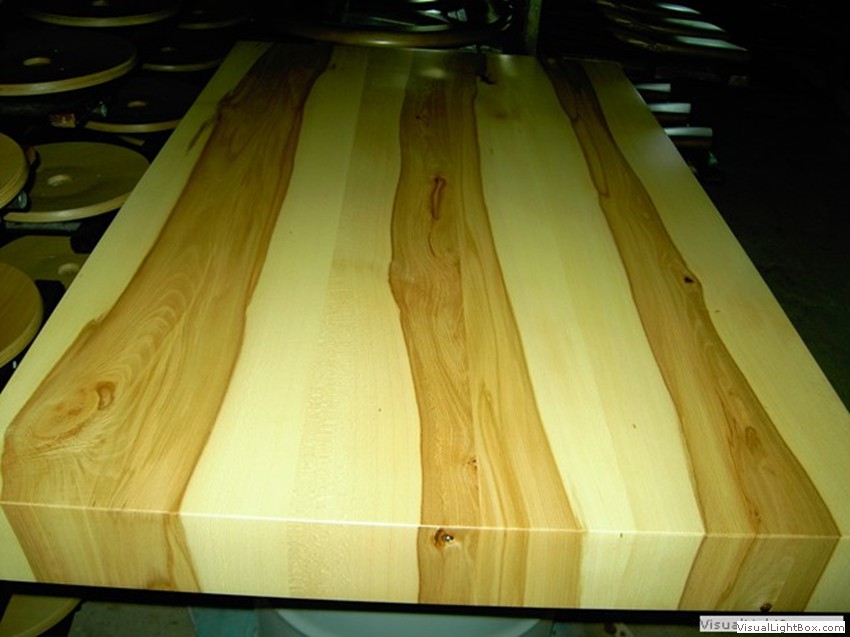 Rechteckige Holzplatte mit sichtbarer Maserung und hellen sowie dunklen Holzstreifen.