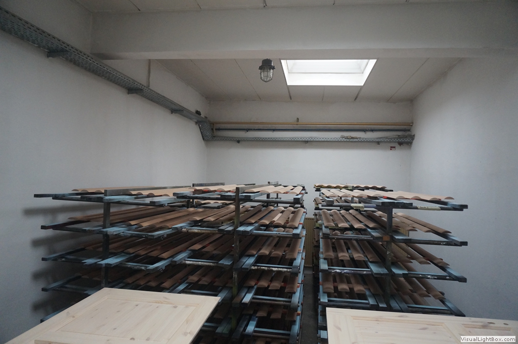 Mehrstöckige Ablagewagen mit Holzleisten in einem hellen Werkstattraum.