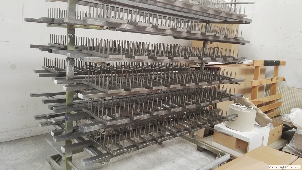 Viele schmale Metallteile auf einem dicht bestückten mehrstöckigen Gestell.