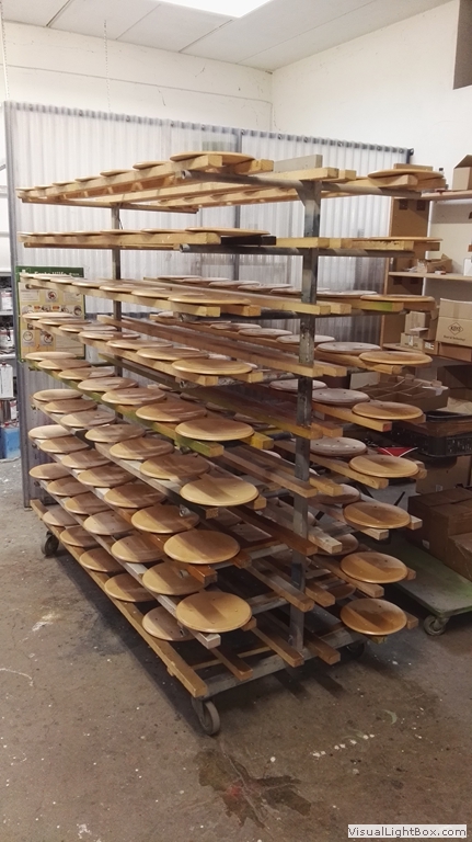 Runde helle Holzplatten auf einem mehrstöckigen rollbaren Ablagegestell.