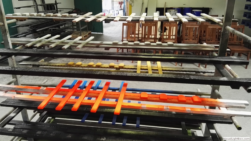 Orangefarbene Leisten und kleine Holzgestelle auf einem mehrstöckigen Ablagewagen.